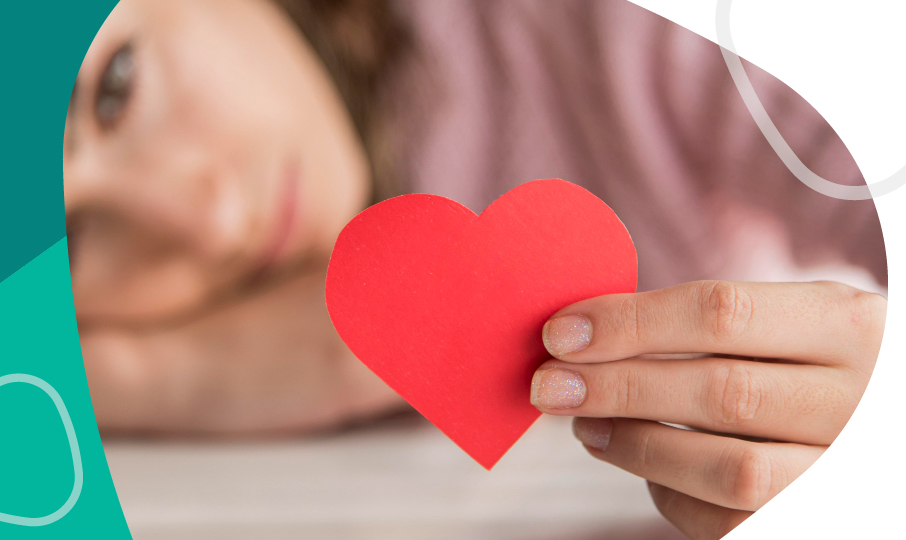 una mujer sosteniendo un corazón de papel